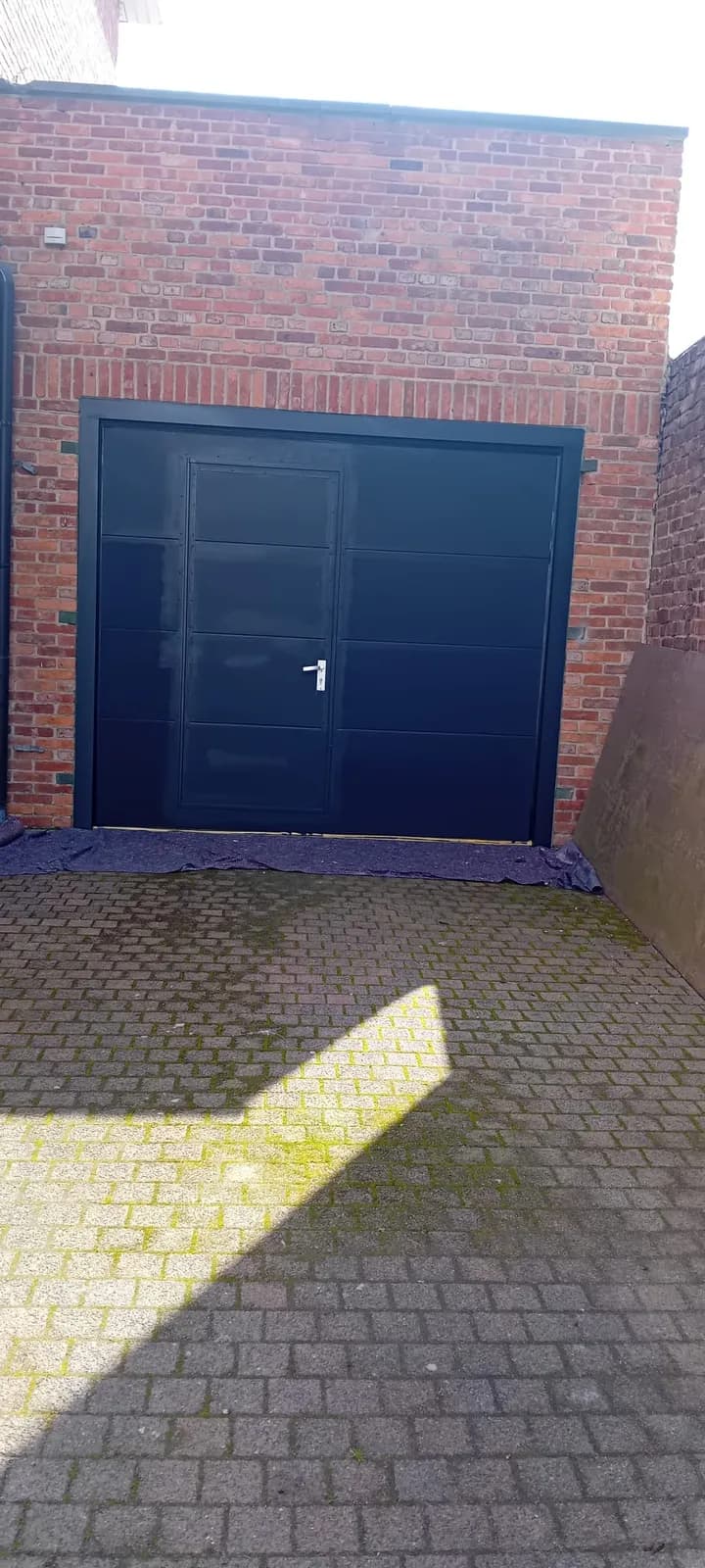 Dezelfde garagepoort na het schilderen in marineblauw