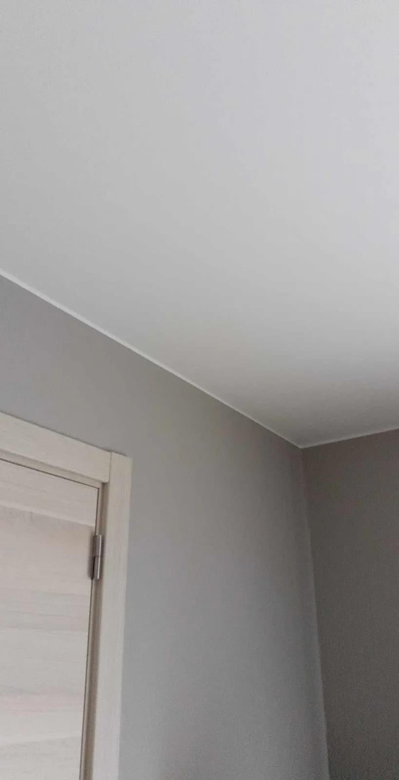 Grijze muur onder schuin plafond